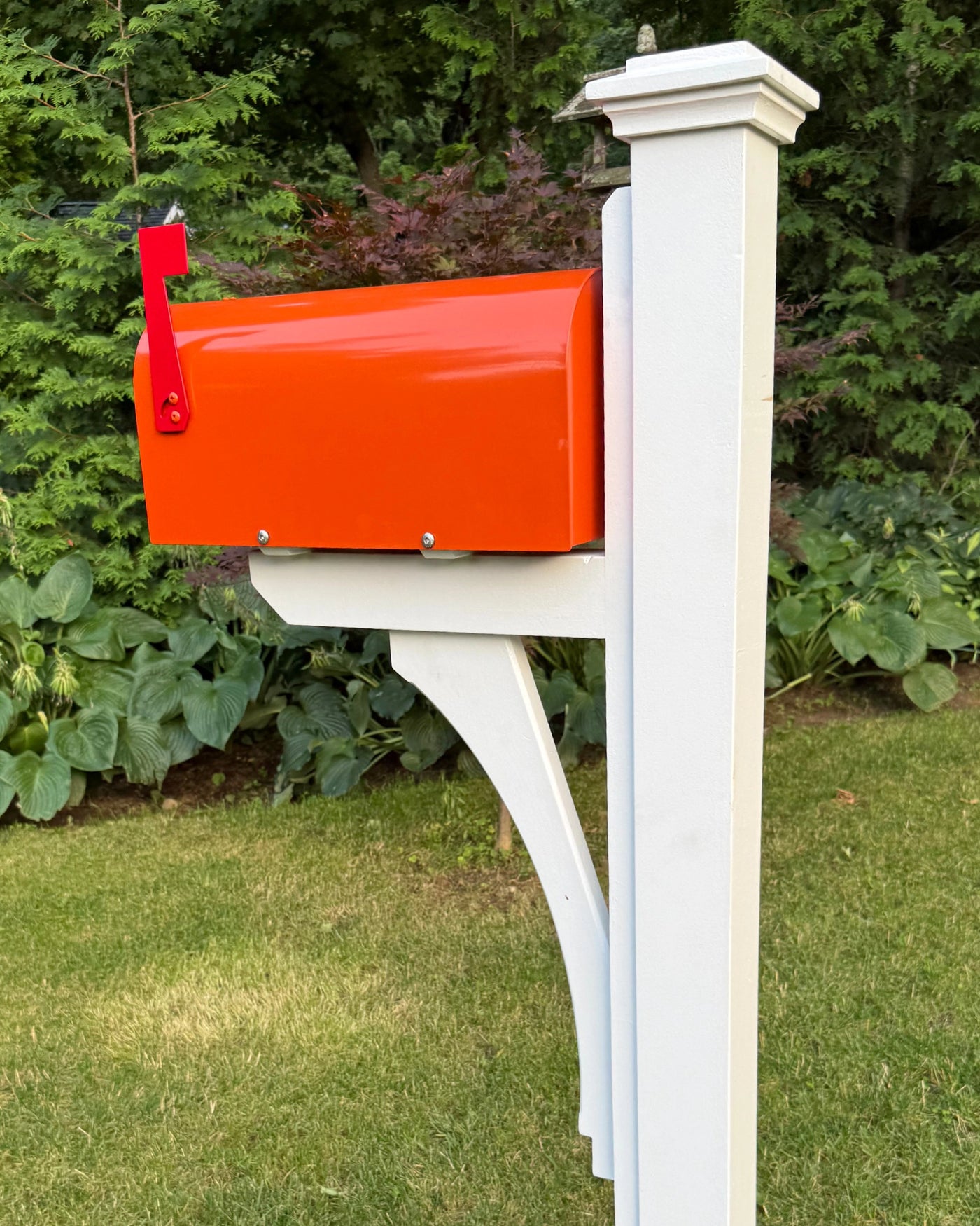 Rear side view of the Classic Orange Mailbox Set featuring a bright orange mailbox, white post, and handcrafted curved bracket.