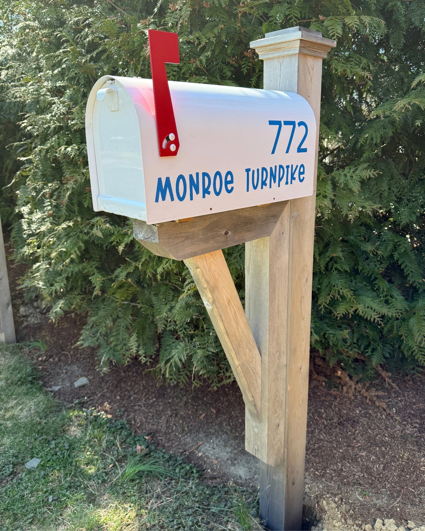 Side view of a white Titan mailbox with custom address lettering and a white cedar post sleeve over a steel core.