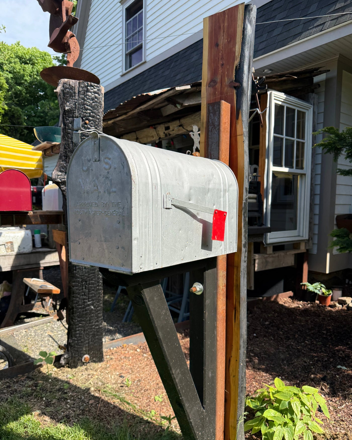 Front view of a vintage-style XL mailbox mounted on a handcrafted cedar slab post with rustic steel reinforcement.