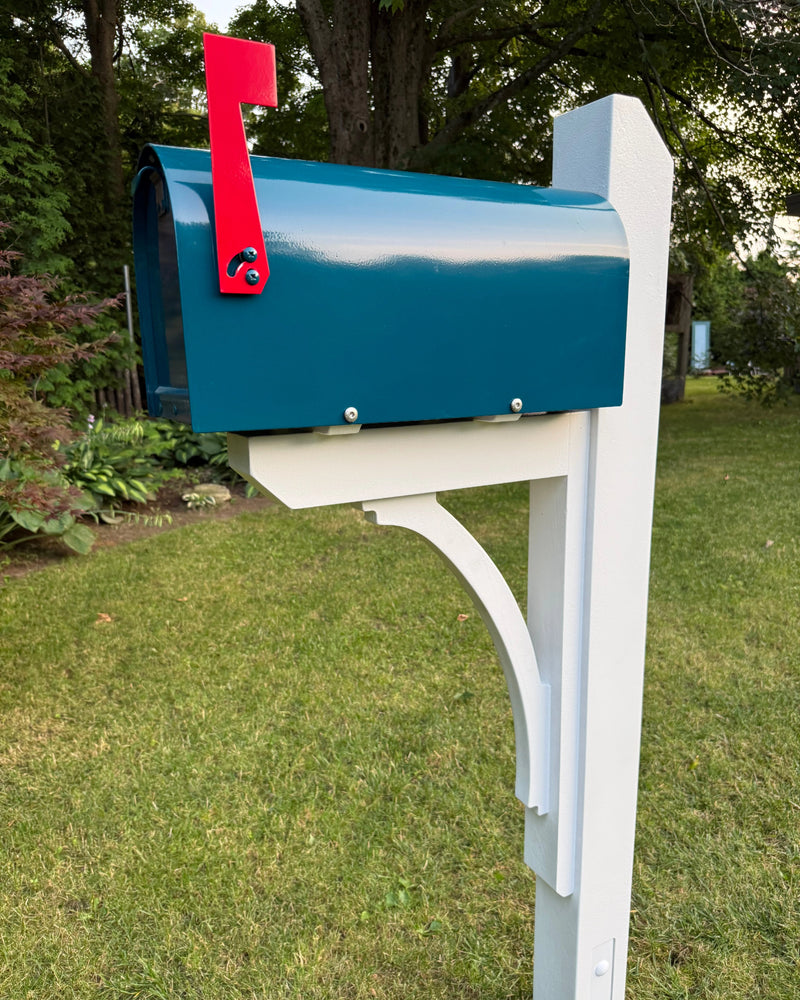 Angled front view of a teal blue mailbox set featuring a white pine post, solid cedar bracket, and bright red mailbox flag.