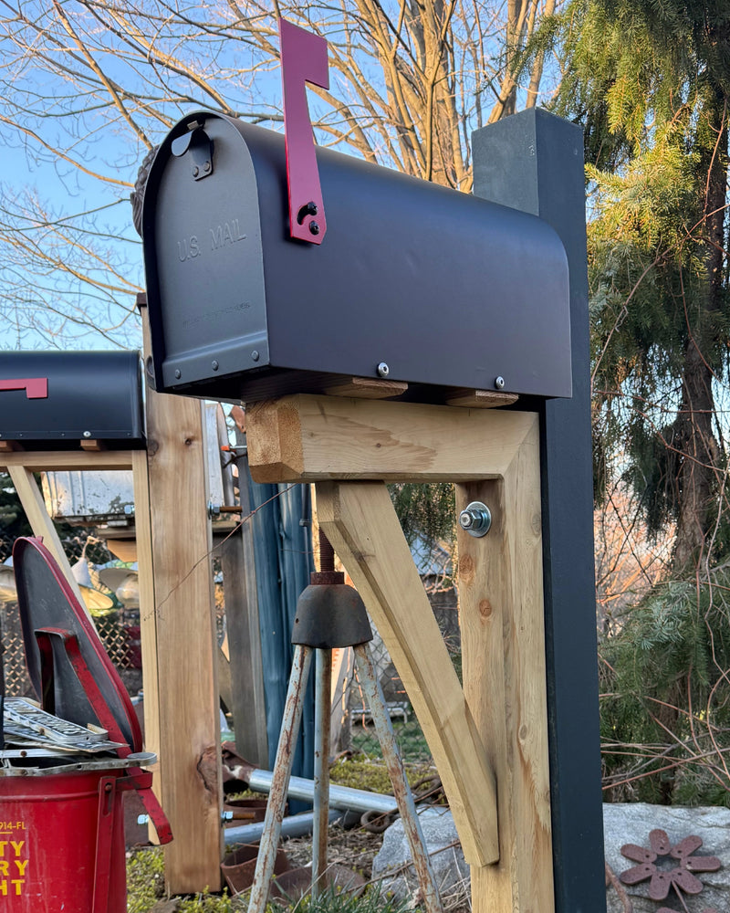 Side view of a matte black vandal-resistant mailbox with natural cedar detailing and a reinforced steel post.