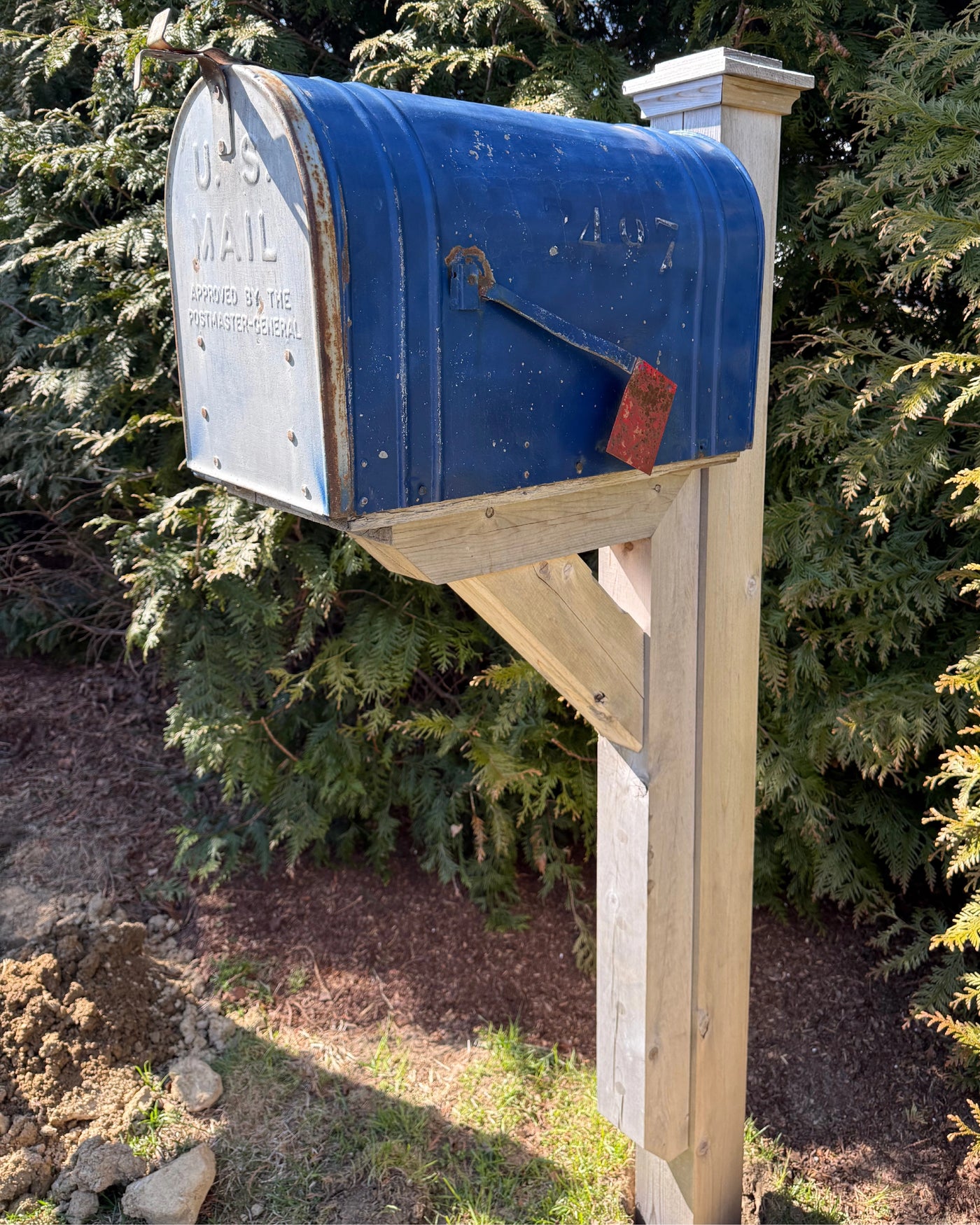 Reclaimed extra-large blue vintage mailbox mounted on a handcrafted white cedar bracket with natural weathered detailing outdoors.