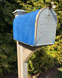 Front view of a reclaimed extra-large blue vintage mailbox with aged metal details mounted on a handcrafted cedar post system.