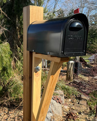 Side view of a black aluminum mailbox set featuring a handcrafted cedar bracket and reinforced 6x6 cedar post.