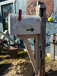 Side view of a weathered XL vintage mailbox paired with a reclaimed wood post and handcrafted cedar support bracket.