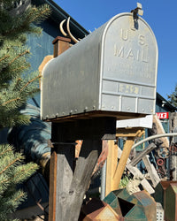 Front angled view of a handcrafted mailbox set combining industrial steel elements with rustic barn wood construction and vintage styling.