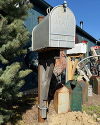 Full view of a rustic industrial mailbox set with a steel post, chestnut barn wood bracket, and oversized vintage-style mailbox.