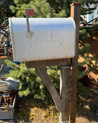 Side view of an XL vintage-style mailbox mounted on a rusted steel post with a handcrafted chestnut barn wood bracket.