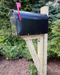 Side view of a black XL architectural mailbox mounted on a pressure-treated wood post with a reinforced bracket assembly.