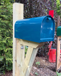 Side view of a black Titan steel mailbox mounted on a pressure-treated wood post with clean modern farmhouse styling.