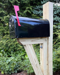 Side view of a white galvanized steel mailbox with a pressure-treated wood bracket and clean handcrafted construction.