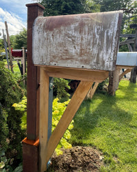 Profile view of a handcrafted farmhouse-style mailbox set with weathered XL mailbox, cedar bracket assembly, and steel post support.
