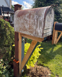 Side view of a weathered vintage-style XL mailbox mounted on a handcrafted cedar bracket with reinforced steel post and rustic detailing.