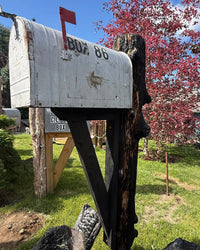 Side view of a handcrafted mailbox set featuring a vintage XL mailbox mounted to a charred cedar log post with black support bracket.
