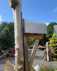 Wide side view of a timeless rustic mailbox set featuring a weathered cedar log post and handcrafted cedar bracket assembly.