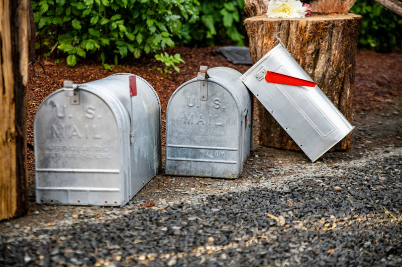 Vintage U.S. mailboxes showcasing weathered metal surfaces and natural aging.