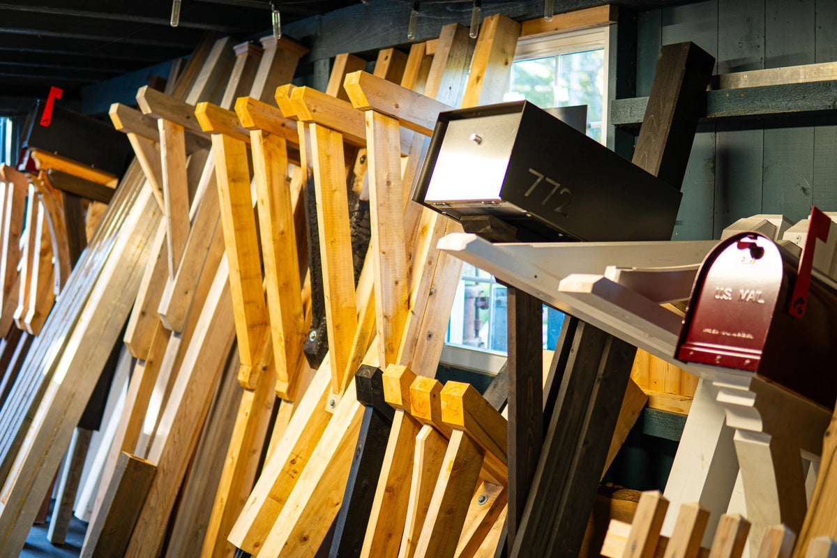 Handcrafted mailbox posts and designs displayed inside the Mrs. Mailbox workshop.